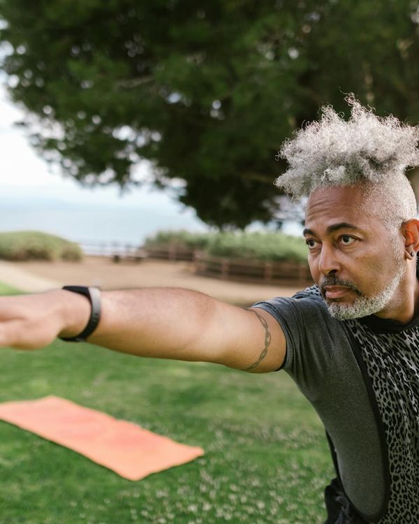 Man practicing a gentle breathing exercise outdoors in a park.